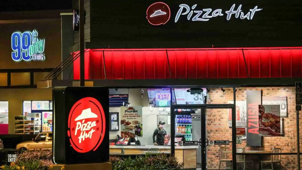 An exterior view of a Pizza Hut seen at night.