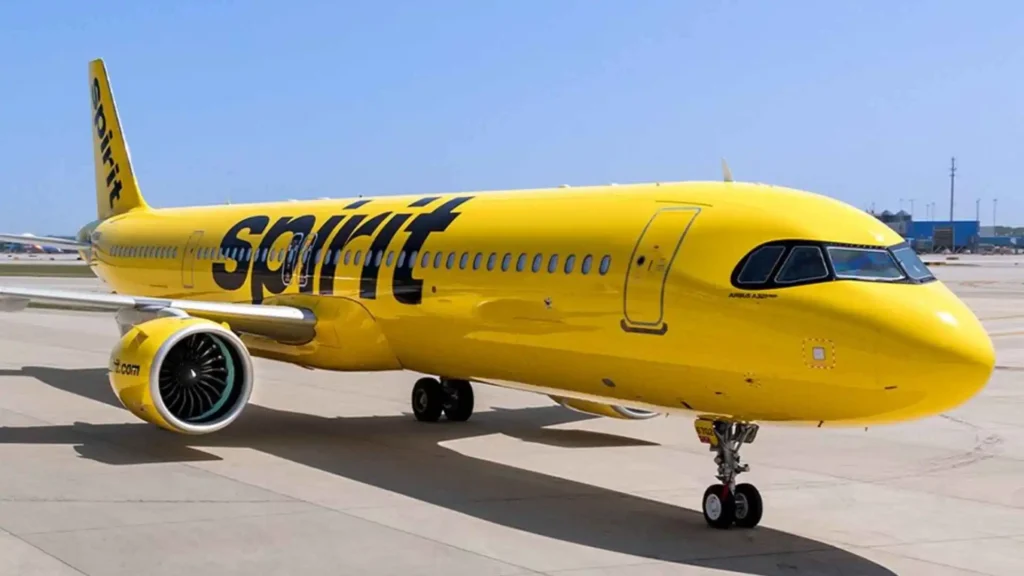 A yellow Spirit Airlines aircraft parked on the tarmac on a sunny day