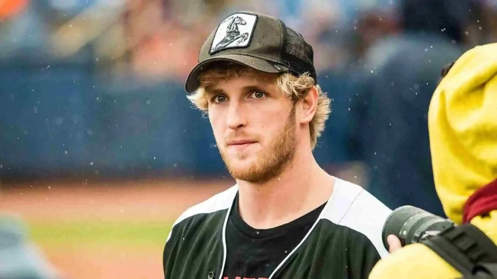Logan Paul wearing a baseball cap and jersey at an outdoor sports event