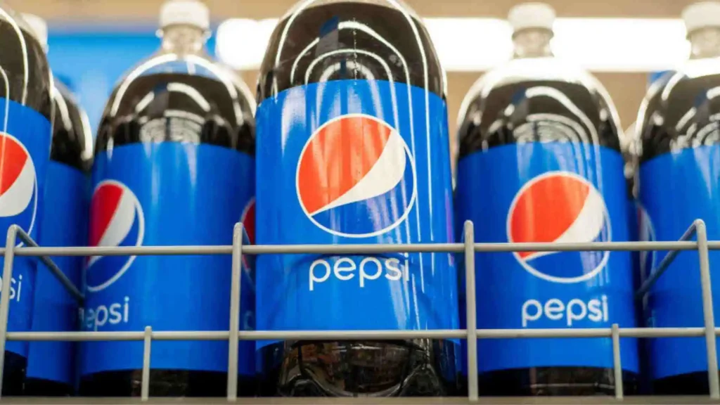 Bottles of Pepsi lined up on a shelf