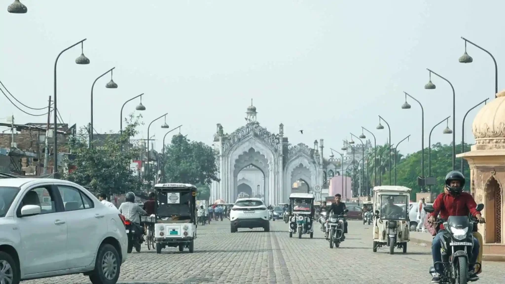 A view of cars and people on bikes on a road in India.